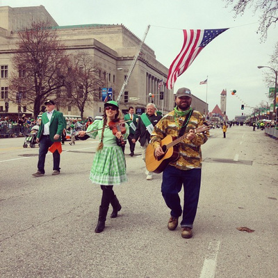 Casey & Minna, Oklahoma folk musicians, march with fiddle and guitar in the Saint Louis Saint Patrick’s Day Parade. 